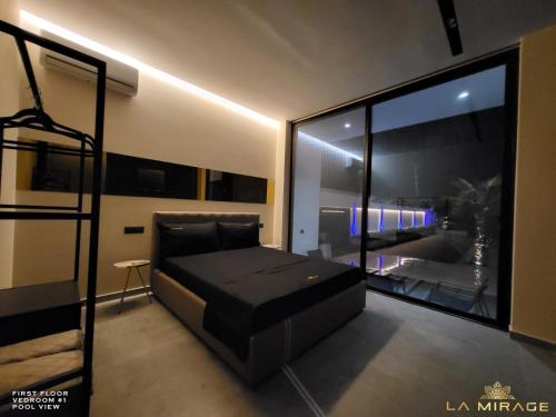 a bedroom with a bed and a large window at La Mirage Villa in Rrushkull