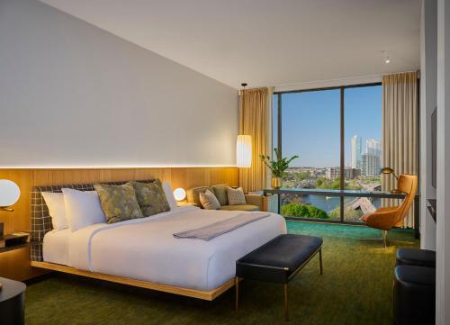 a hotel room with a bed and a large window at The Loren at Lady Bird Lake in Austin