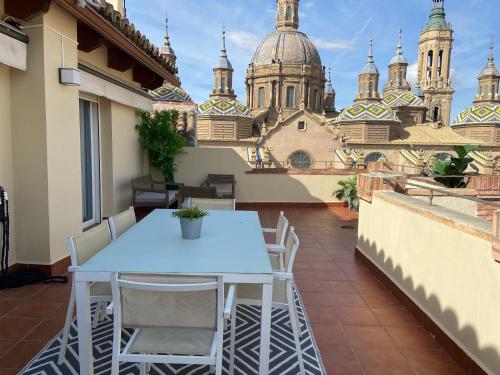 een tafel en stoelen op een balkon met uitzicht op een gebouw bij Rooftop Alfonso in Zaragoza