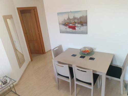 a white dining room table and chairs with a painting on the wall at Casa de Melanie e Marko in San Juan de los Terreros