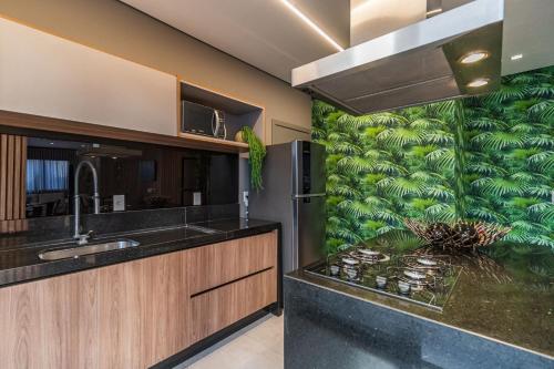 a kitchen with a counter with a green wall at Condomínio Residencial Unique Residence - São José do Rio Preto in Sao Jose do Rio Preto