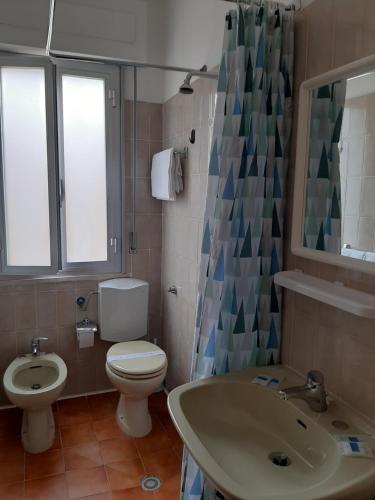 a bathroom with a toilet and a sink at Hotel Cucciolo in Donoratico