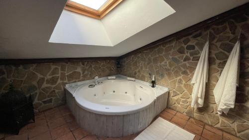 a large bath tub in a bathroom with a skylight at Casa Rural La Buhardilla in Benaocaz