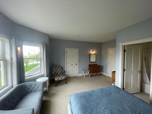 a bedroom with a bed and a couch and a desk at The Edenwild Boutique Inn in Lopez
