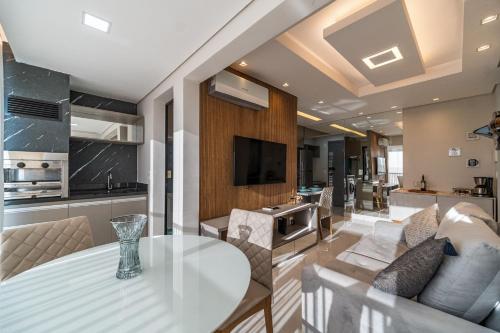 a kitchen and living room with a glass table in a room at Condomínio Residencial Unique Residence - São José do Rio Preto in Sao Jose do Rio Preto
