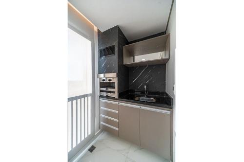 a kitchen with grey cabinets and a window at Condomínio Residencial Unique Residence - São José do Rio Preto in Sao Jose do Rio Preto
