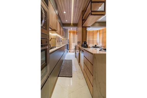 a kitchen with wooden cabinets and a long hallway at Condomínio Residencial Unique Residence - São José do Rio Preto in Sao Jose do Rio Preto