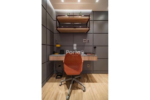 an office with an orange chair sitting at a desk at Condomínio Residencial Unique Residence - São José do Rio Preto in Sao Jose do Rio Preto