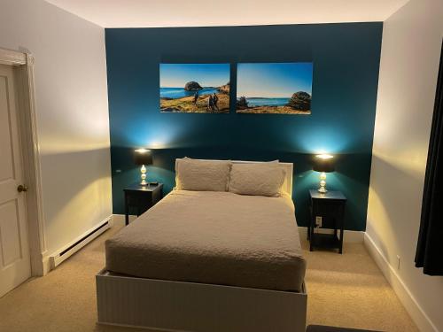 a bedroom with a bed and two pictures on the wall at The Edenwild Boutique Inn in Lopez