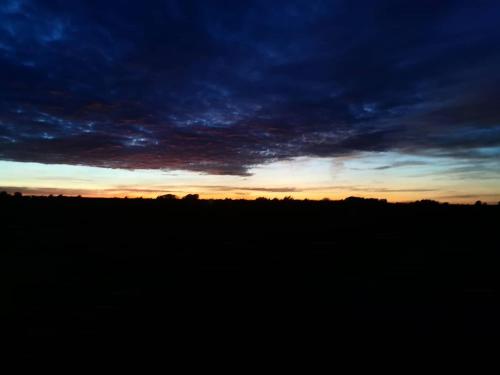 a sunset over a field with a dark sky at Miradoralaribera Chalet rural in Alcoba de la Ribera
