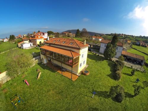 an overhead view of a house on a green field at La Cochera de Somao, casona de tipología indiana in Somado