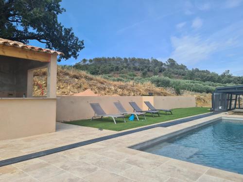 - un groupe de chaises assises à côté de la piscine dans l'établissement Gîte De La Guerine, à Cabasse