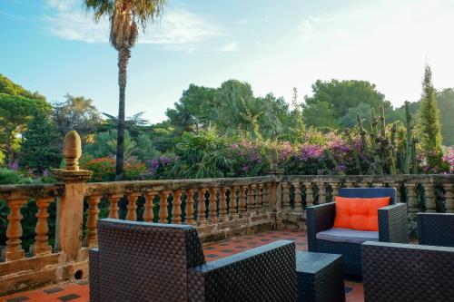 an outdoor patio with chairs and a fence and flowers at Open Sky Villa in Denia