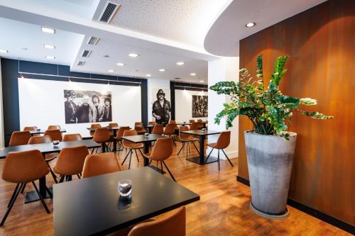 un restaurante con mesas y sillas y una maceta en Internationales Studierendenhotel, en Stuttgart