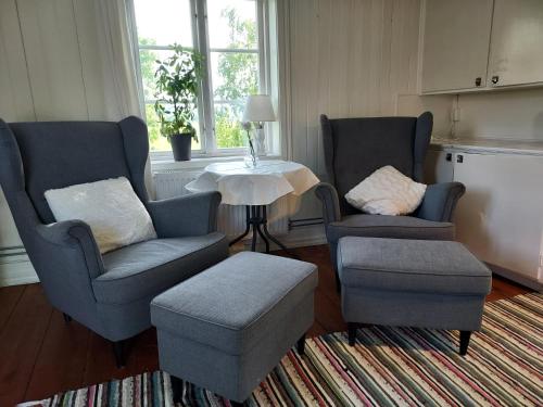 a living room with two chairs and a table at Älgbergets Bed & Breakfast in Ucklum