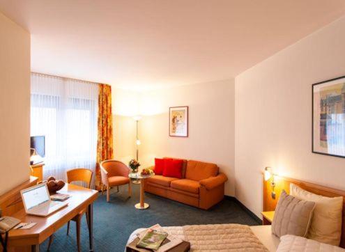 a living room filled with furniture and a large window at Hotel Panorama Hamburg-Harburg in Hamburg