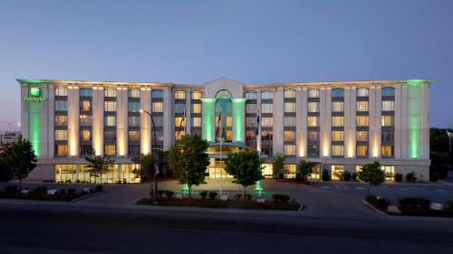 un gran edificio con luces verdes delante de él en Holiday Inn & Suites Montreal Airport, en Dorval