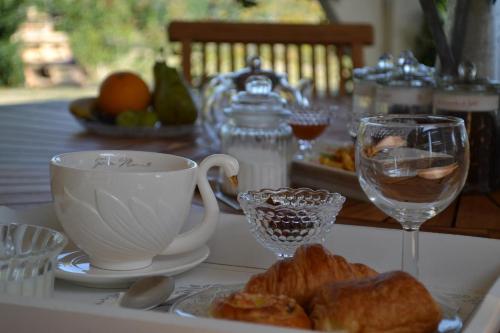una mesa con un plato de bollería y una taza y un vaso en Chambre d’hôtes Mamounet Haut, en Madaillan