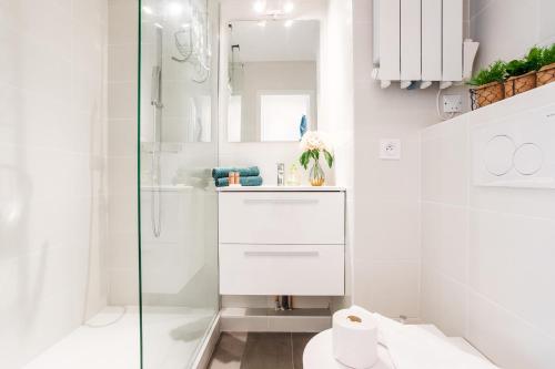 une salle de bain blanche avec douche et toilettes dans l'établissement L'ANGE GARDIEN III AP4293 By Riviera Holiday Homes, à Villefranche-sur-Mer
