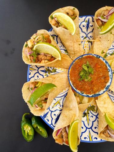 a blue and white plate with tacos and a bowl of salsa at Hotel and Dive Center Roatan Yacht Club in Roatán