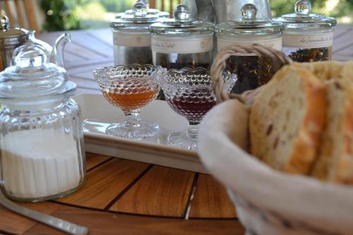 una mesa con copas de vino y una bandeja de pan en Chambre d’hôtes Mamounet Haut, en Madaillan