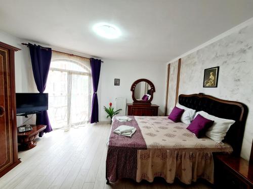 阿爾巴·尤利亞·的住宿－Pension Terra，一间卧室配有一张带紫色枕头的大床