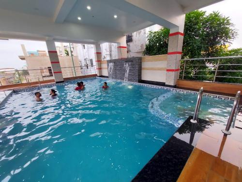 a group of people in a swimming pool at Blue Stone Hotel & Restaurant Mandarmani in Mandarmoni