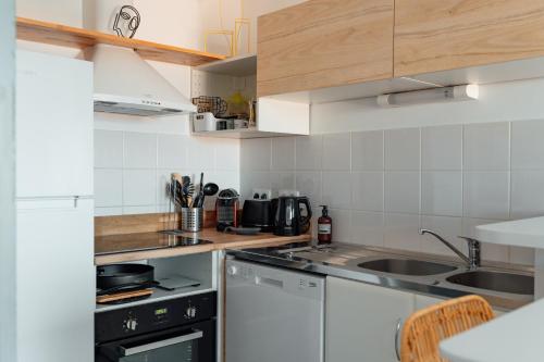 une cuisine avec une cuisinière et un évier dans l'établissement Down Center - Incroyable vue mer proche plage, à Arcachon