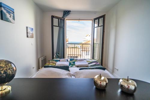 a bedroom with a bed and a large window at Down Center - Incroyable vue mer proche plage in Arcachon