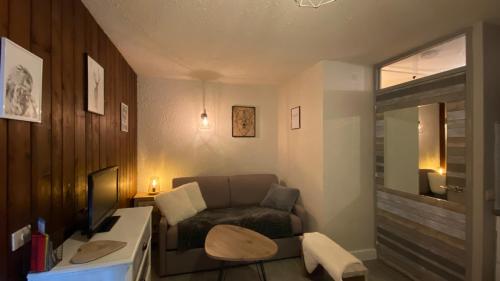 uma sala de estar com um sofá e uma cadeira em Le Cosy Vertigineux em Uvernet