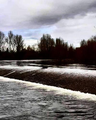 a river with snow on the side of it at Miradoralaribera Chalet rural in Alcoba de la Ribera