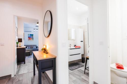 Cette chambre comprend un bureau et une salle de bains pourvue d'un miroir. dans l'établissement LE TIVOLI II AP4282 By Riviera Holiday Homes, à Nice