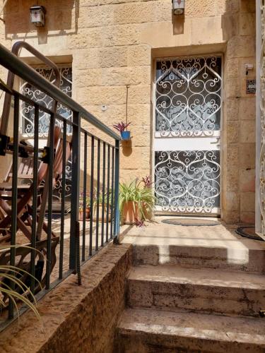 a door with a wrought iron gate on a building at Legatia in Jerusalem