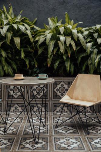 a table and a chair in front of some plants at Sui Boutique Hotel in Medellín