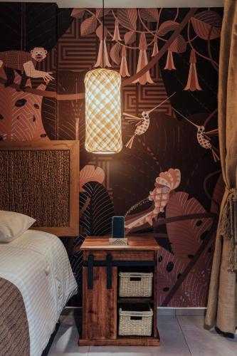 a bedroom with a bed and a table with a phone at Sui Boutique Hotel in Medellín