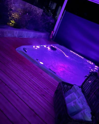 a jacuzzi tub with purple lighting in a backyard at DU GLACIER Boutique & Traditions Hotel in Fiesch