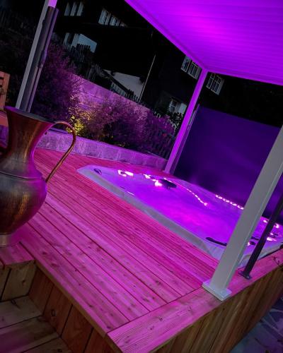 a jacuzzi tub with purple lighting on a porch at DU GLACIER Boutique & Traditions Hotel in Fiesch
