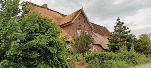 une grande maison en briques avec un toit dans l'établissement De Olle Uhlhoff, à Barlt