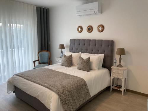 - une chambre avec un grand lit et une chaise bleue dans l'établissement Quinta Vale de Palheiros, à Santa Comba Dão