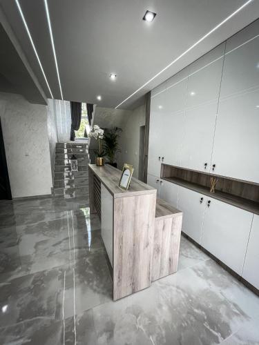 a kitchen with white cabinets and a counter at Apartmani Mila in Laktaši
