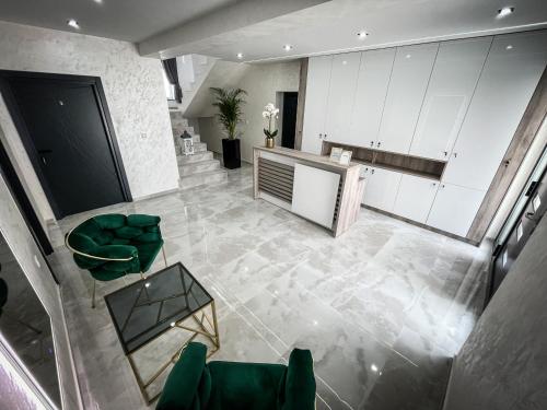 uma vista superior de uma cozinha com cadeiras verdes em Apartmani Mila em Laktasi