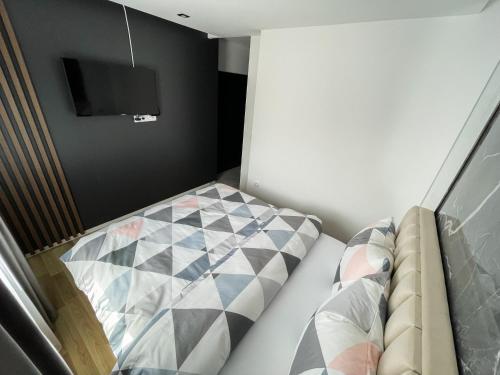 a small room with a bed and a tv at Apartmani Mila in Laktaši