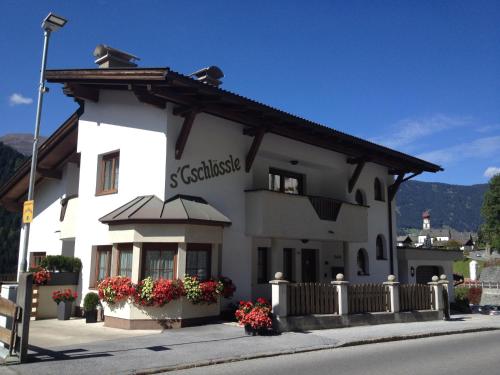 a white building with flowers in front of it at Gschlössle Ferienwohnungen in Jerzens