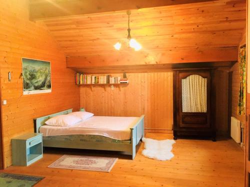 une chambre avec un lit dans une pièce en bois dans l'établissement Chalet familial 2*, proche pistes et centre, terrasse sud, vue montagnes - FR-1-618-10, à Albiez-Montrond