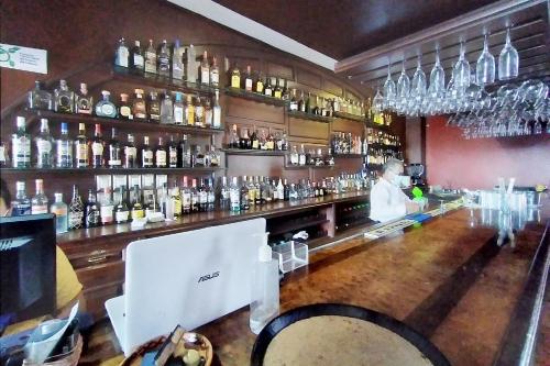 a bar with a man standing behind the bar at Hotel Maria Victoria Xalapa in Xalapa