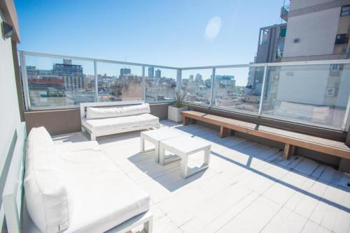 a balcony with white furniture and a view of a city at Studio en Palermo Soho in Buenos Aires