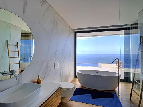 a bathroom with a large tub and a large window at Heaven's Nest by LovelyStay in Ribeira Brava