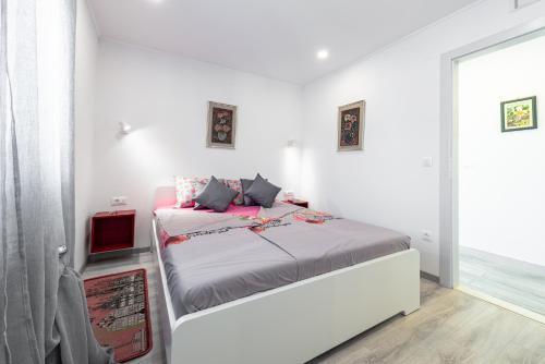 ein weißes Schlafzimmer mit einem Bett und einem Fenster in der Unterkunft Apartment Bobara in Mlini