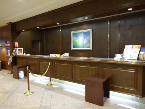 a lobby with a long bar with a yellow rope at Hotel Higashinihon Utsunomiya in Utsunomiya