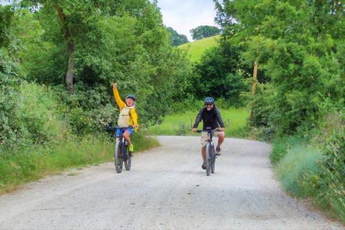 two people riding bikes down a dirt road at Agriturismo La Meria in Semproniano